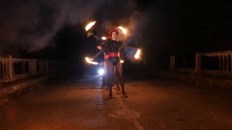 Girl and guy dancing with fire in the dark Stock Footage 71539497