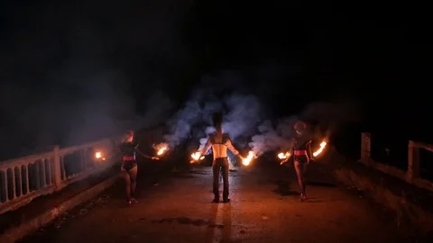 Girl and guy dancing with fire in the dark Stock Footage 71539859