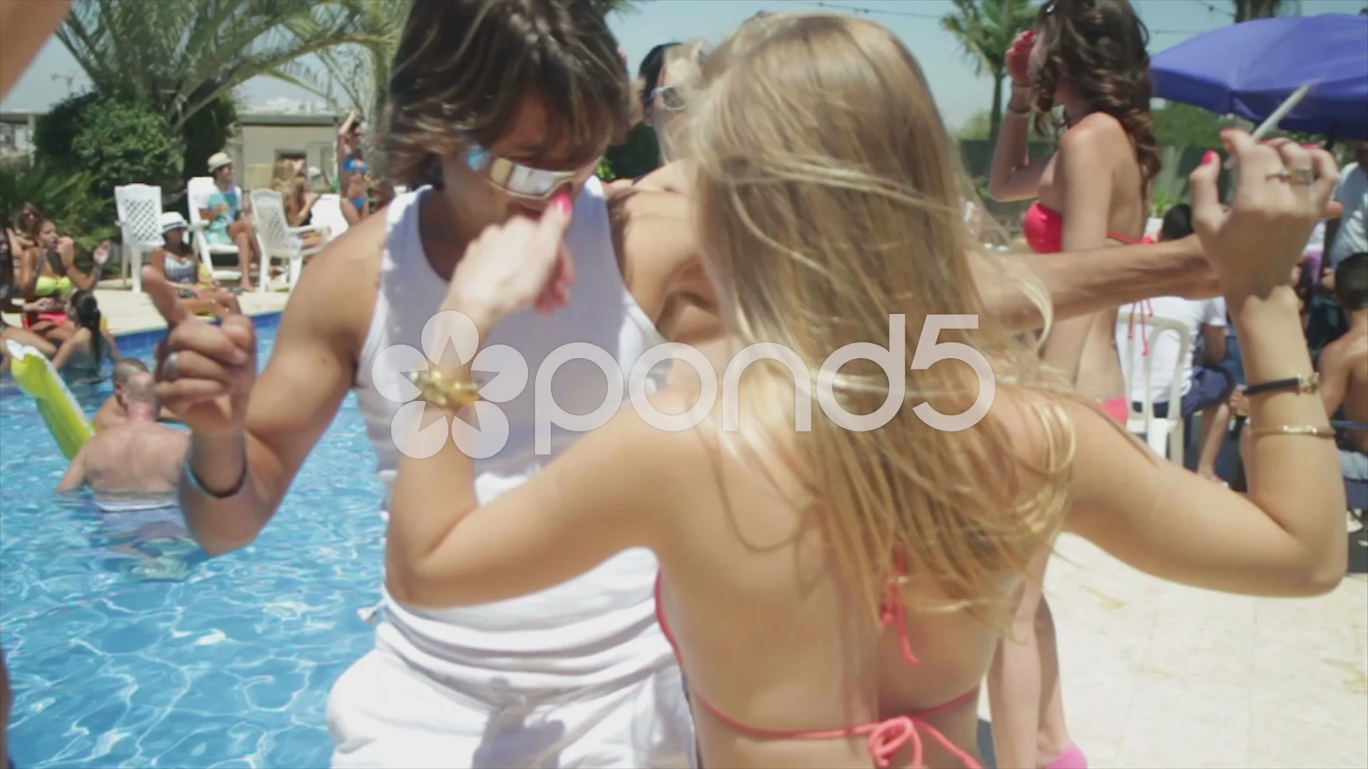 Girl and a guy dancing in a pool party