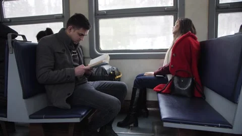 Girl and Guy sit on Opposite Each Other on the Train Video stock 144635720