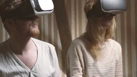 Girl and her boyfriend hold hands and plunge into the world of virtual reality Stock Footage