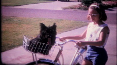 Girl and her dog ride bicycle in neighborhood 1950s vintage film home movie 2287 Stock Footage