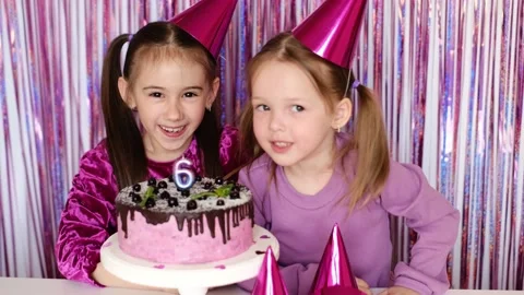 Girl and sister blow out a candle togeth... | Stock Video | Pond5