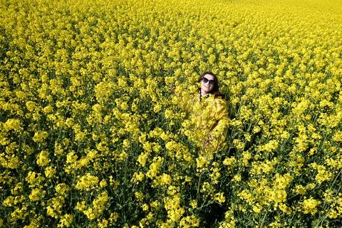 Girl and yellow flowers of rapeseed. Oilseed plant. Travel outside the city.  Stock Photos