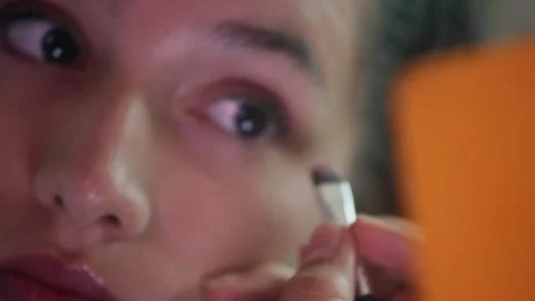 Girl applying eye makeup while looking in a mirror Video stock 275015022
