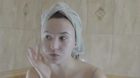 The girl is applying makeup. The camera makes a reflection in the mirror. Vídeo Stock 95553094