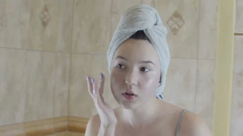 The girl is applying makeup. The camera makes a reflection in the mirror. Stock-Footage 95553611