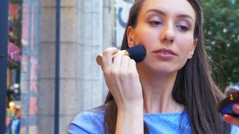 Girl applying makeup while she waiting for her boyfriend in the city Stock Footage 97139579