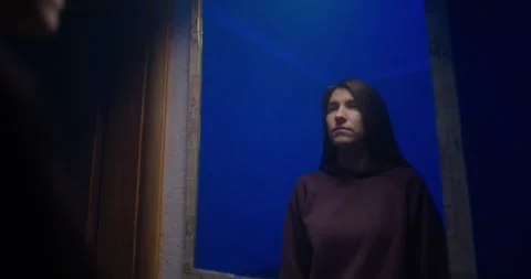 Girl approaching mirror in blue light, medium close-up Stock Footage 325092004