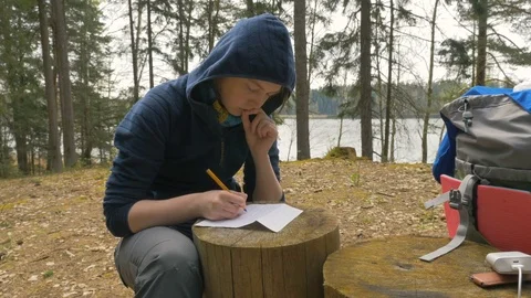 Girl are writing notes on the stump in the forest Stock Footage