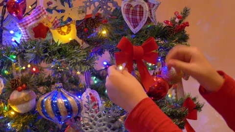 Girl is arranging the red bow on the Christmas tree 動画素材 144117953