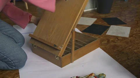 Girl artist disassembles an easel for drawing pictures in a design studio Stock Footage 171155018