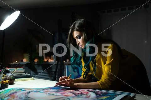 Girl artist signs some of his works. Painted sign of a master. Canvas on a Stock Photos