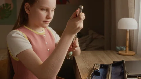 Girl Assembling Silver Flute at Desk for Online Music Lesson Stock Footage 336184136