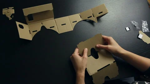 Girl assembling a Virtual Reality cardboard glasses Stock Footage 66612537