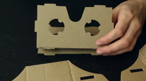 Girl assembling a Virtual Reality cardboard glasses Stock Footage 66622312