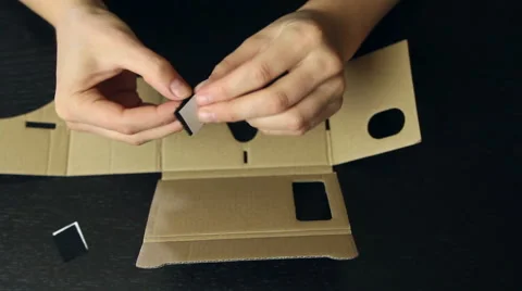 Girl assembling a Virtual Reality cardboard glasses Stock Footage 66636822