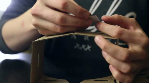 Girl assembling a Virtual Reality cardboard glasses Stock Footage 66641937