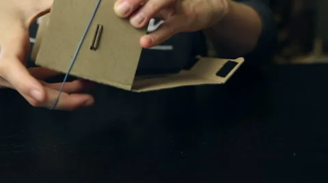 Girl assembling a Virtual Reality cardboard glasses Stock Footage 66670270