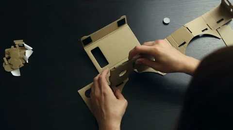 Girl assembling a Virtual Reality cardboard glasses Stock Footage 66680030