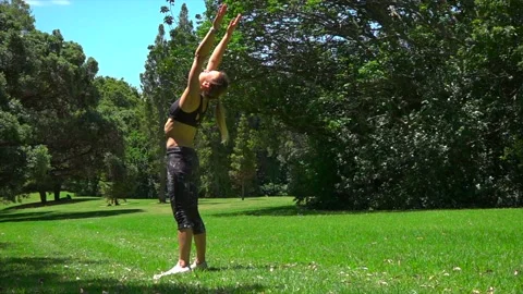 Girl athlete does physical exercise on green grass in the forest in new zealand Stock-Footage 131955786