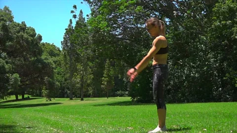 Girl athlete does physical exercise on green grass outdoors Stock Footage 131955841