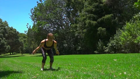 Girl athlete does physical exercise on green grass in the forest in new zealand Stock-Footage 131956017