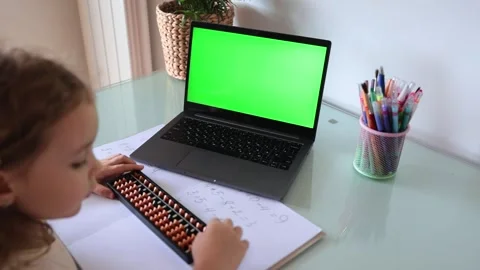 A girl from the back is engaged in mental arithmetic on the abacus online on a Stock Footage 258565403