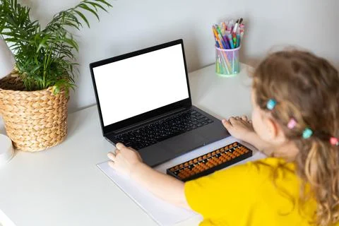 A girl from the back is engaged in mental arithmetic on the abacus online on a Stock Photos