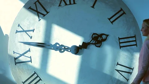 Girl on the background of the clock shows a hand sign of good luck. Stock Footage 69901102