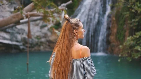 Girl on the background of a waterfall Stock Footage 129058636
