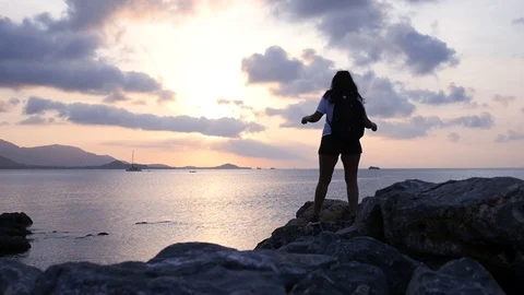 A girl with a backpack behind her back enjoys the beautiful scenery on the sea Stock Footage 93801698