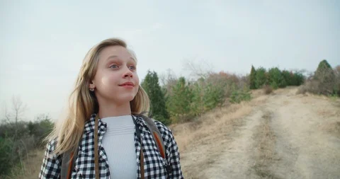 Girl with a backpack, looking through binoculars in the mountains in the fall. 4 Stock Footage 98776248