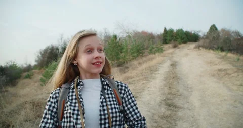 Girl with a backpack, looking through binoculars in the mountains in the fall. 4 Stock Footage 98776536