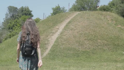 A girl with a backpack rises a hill Stock Footage 90905810