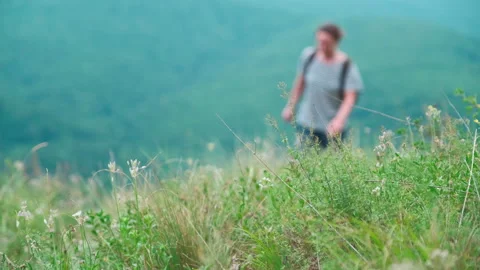 Girl with a backpack rises uphill in the background of a beautiful landscape. Stock Footage 157723283