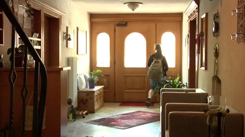 Girl with a backpack running down the stairs and out of home - view from inside. Stock Footage 32374557