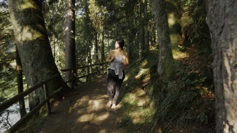 Girl with a backpack walking in the woods Stockbeeldmateriaal 89591132