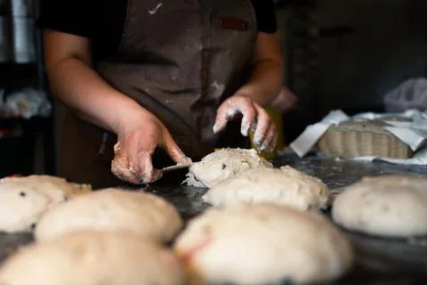 Girl baker forms bread on the table Stock Photos