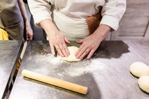 Girl baker forms bread on the table Stock Photos
