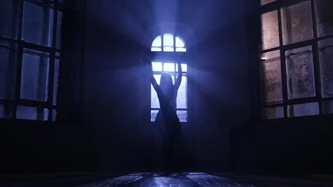 Girl ballerina dances near window in moonlight, silhouette. Slow motion Stock Footage
