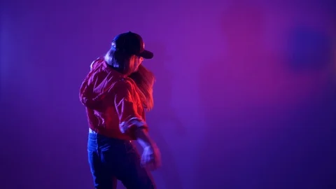 Girl in a baseball cap dancing hip hop on a purple background,isolated Vídeo Stock 107496128