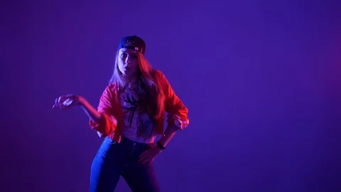 Girl in a baseball cap dancing hip hop on a purple background,isolated Stock-Footage 107496162