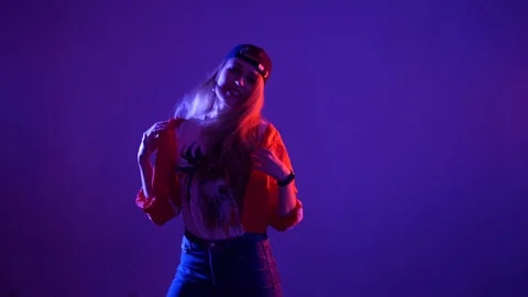 Girl in a baseball cap dancing hip hop on a purple background,isolated Video stock 107496173
