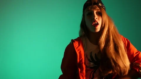 Girl in a baseball cap dancing hip hop on a green background,isolated Stock Footage 107496262