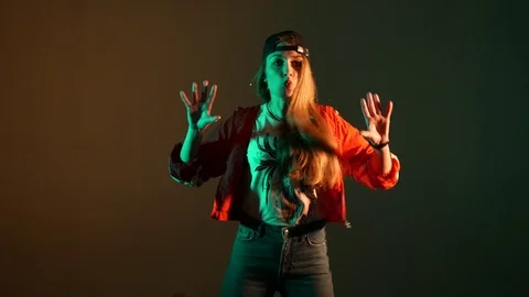 Girl in a baseball cap dancing hip hop on a brown background,isolated Stock-Footage 107496283