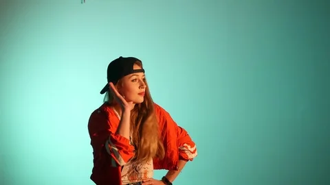 Girl in a baseball cap dancing hip hop on a green background,isolated Video stock 107496327