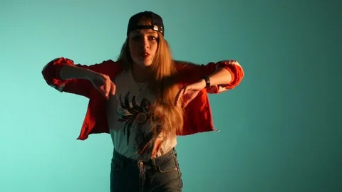 Girl in a baseball cap dancing hip hop on a green background,isolated Video stock 107496353