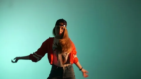 Girl in a baseball cap dancing hip hop on a green background,isolated 库存影片 107496364