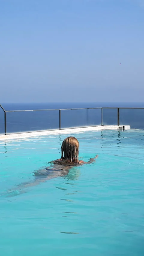 Girl bathing in the pool overlooking the ocean Stock Footage 265060104